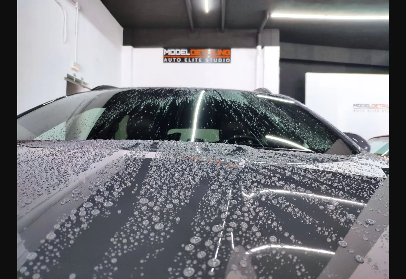 Gotas de agua sobre una carrocería recién tratada, mostrando un comportamiento hidrofóbico marcado, en el estudio de Model Detailing.