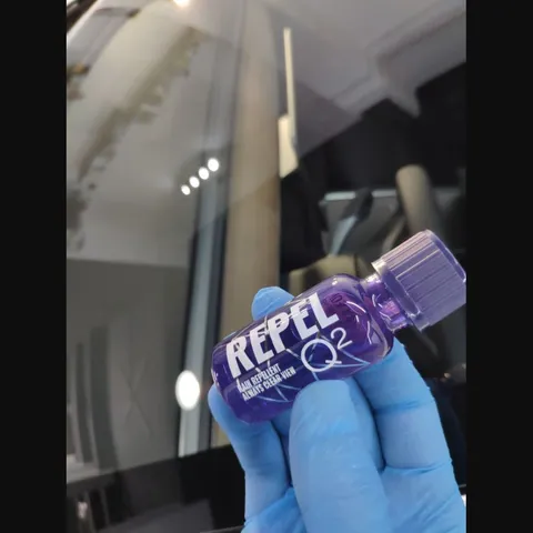 Producto repelente de agua para cristales aplicado sobre una luna de vehículo.